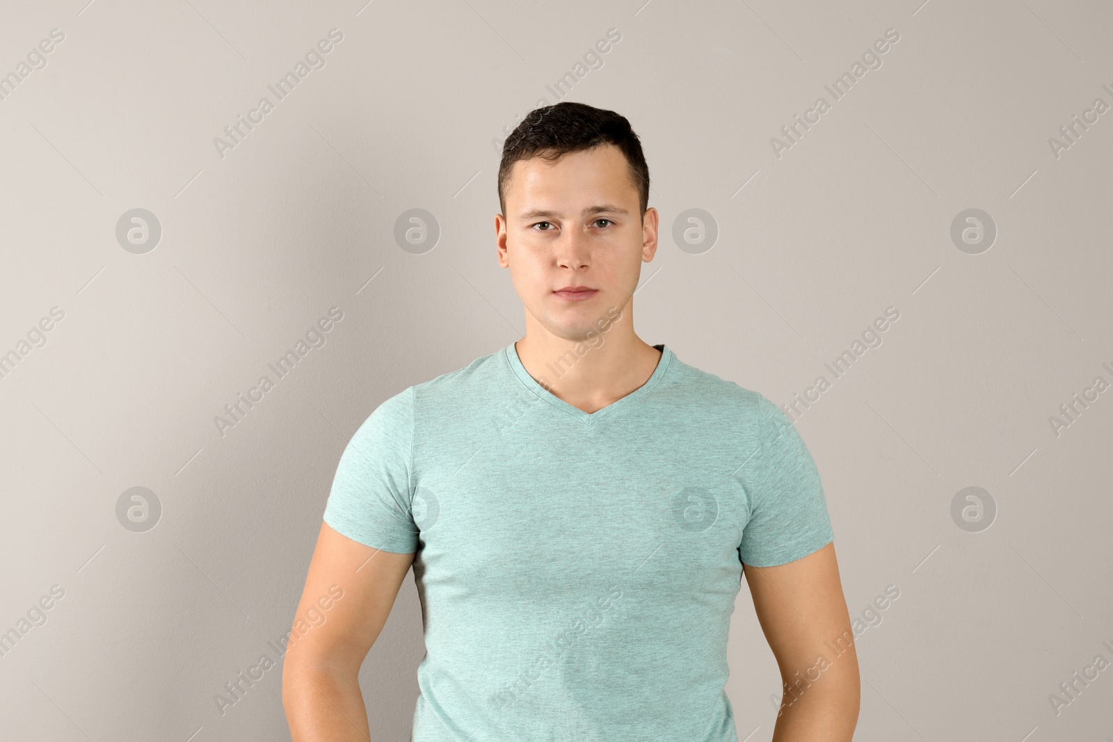 Photo of Confident handsome young man on beige background