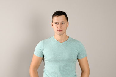 Photo of Confident handsome young man on beige background