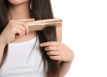 Photo of Young woman with wooden hair comb on white background, closeup