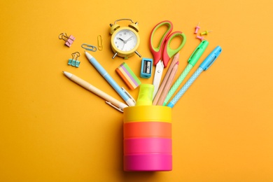 Photo of Flat lay composition with school stationery on orange background. Back to school