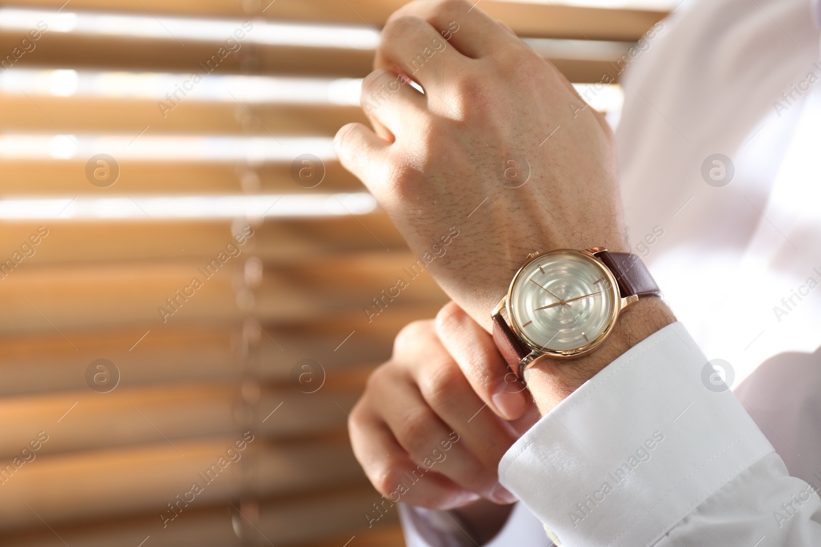 Photo of Man with luxury wrist watch on blurred background, closeup. Space for text