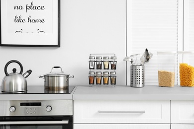 Photo of Modern kitchen interior with new furniture and different utensils