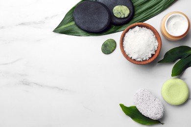 Photo of Flat lay composition with spa products and green leaves on white marble table. Space for text