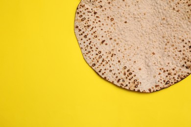 Photo of Tasty matzo on yellow background, top view with space for text. Passover (Pesach) celebration