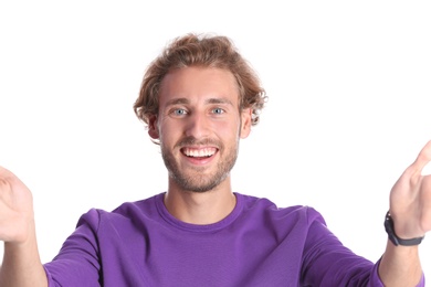 Photo of Handsome young man laughing and taking selfie on color background