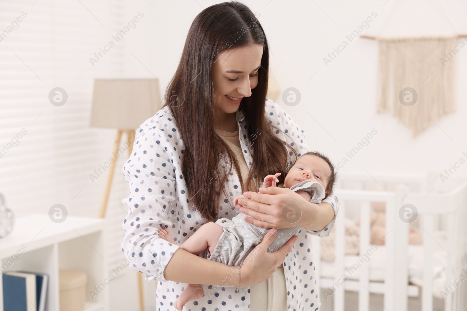 Photo of Mother with her cute newborn baby at home