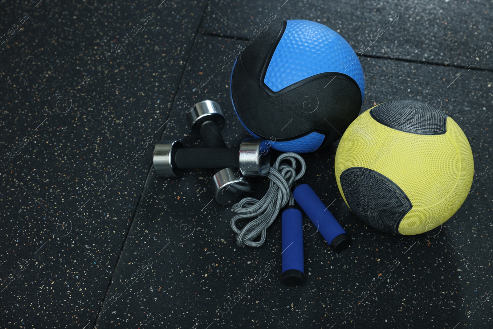 Photo of Medicine balls, dumbbells and skipping rope on floor, space for text