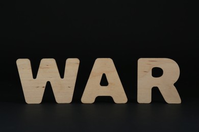 Photo of Word War made of wooden letters on black background