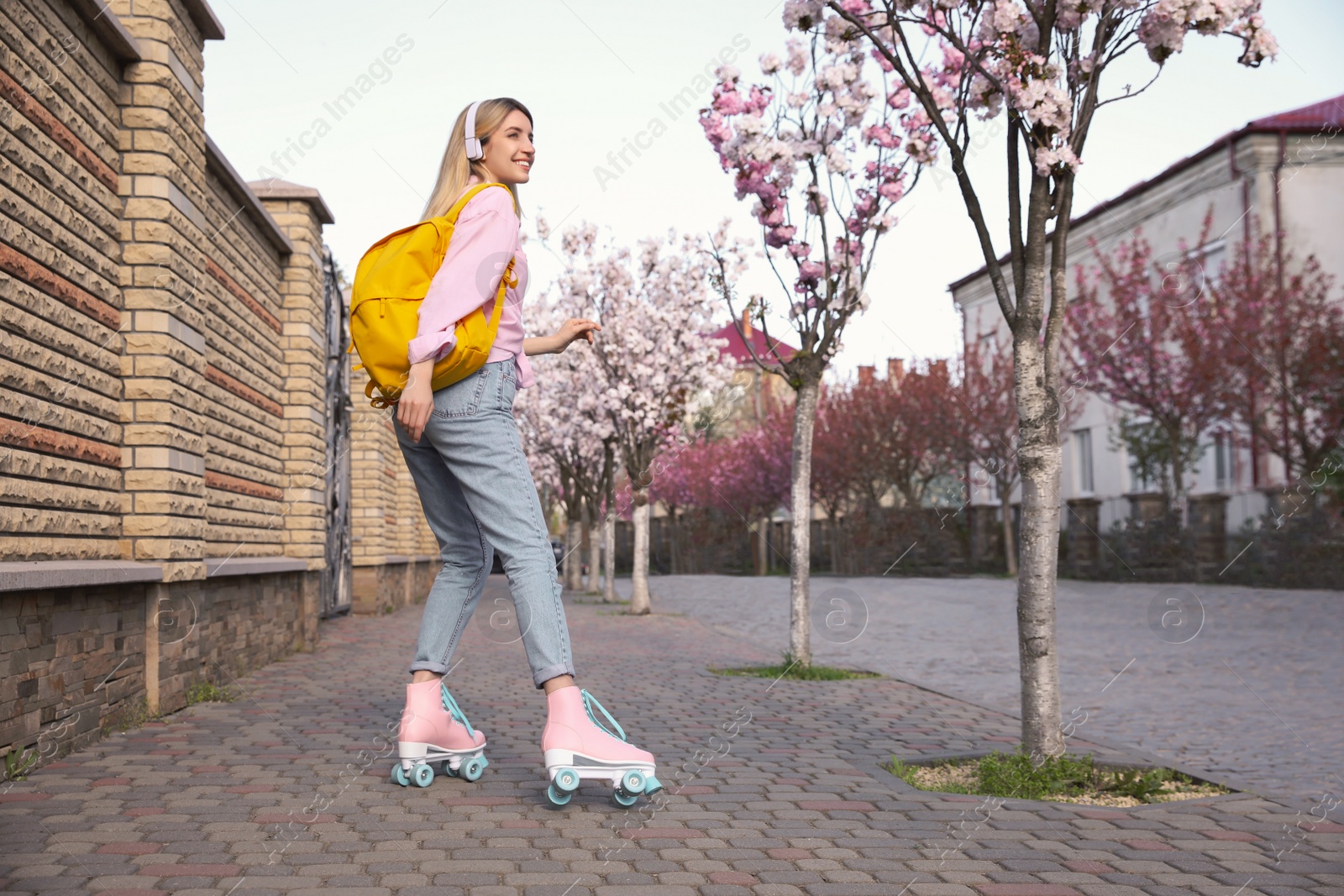 Photo of Young woman roller skating on city street