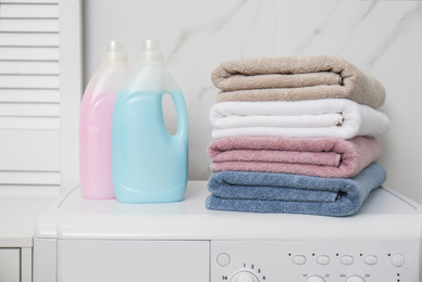 Photo of Stack of fresh towels and detergents in laundry room