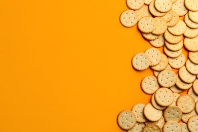 Delicious crackers on orange background, flat lay. Space for text