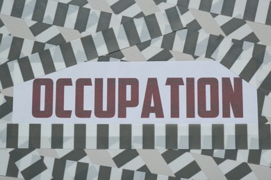 Word Occupation attached with adhesive tape on light background, top view