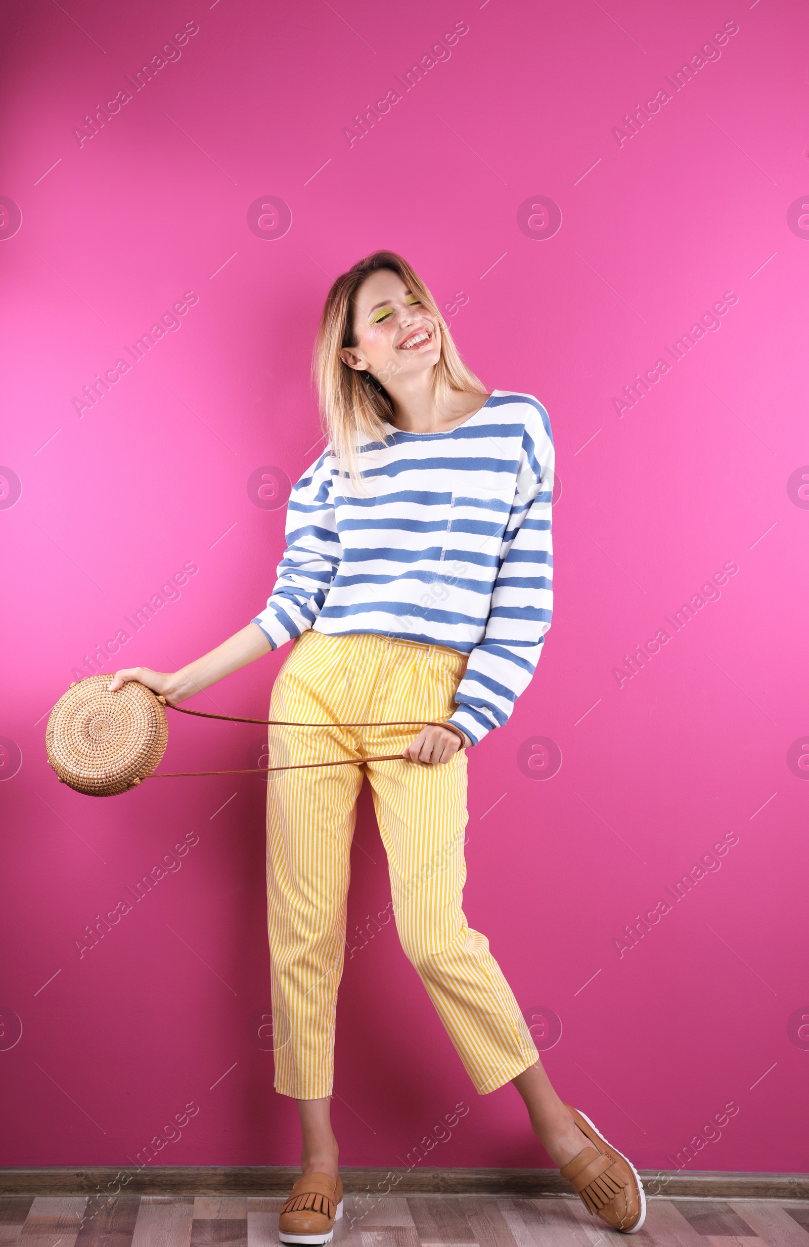 Photo of Beautiful young woman posing near color wall. Summer fashion