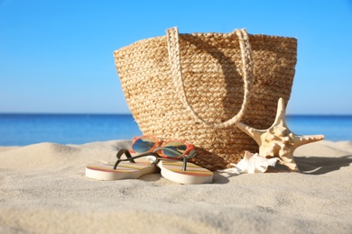 Photo of Set with stylish beach accessories on sand near sea