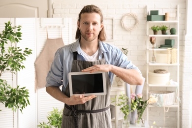 Male florist holding tablet at workplace