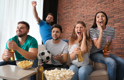 Group of friends watching football at home