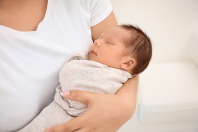 Photo of Young mother holding cute newborn baby, closeup