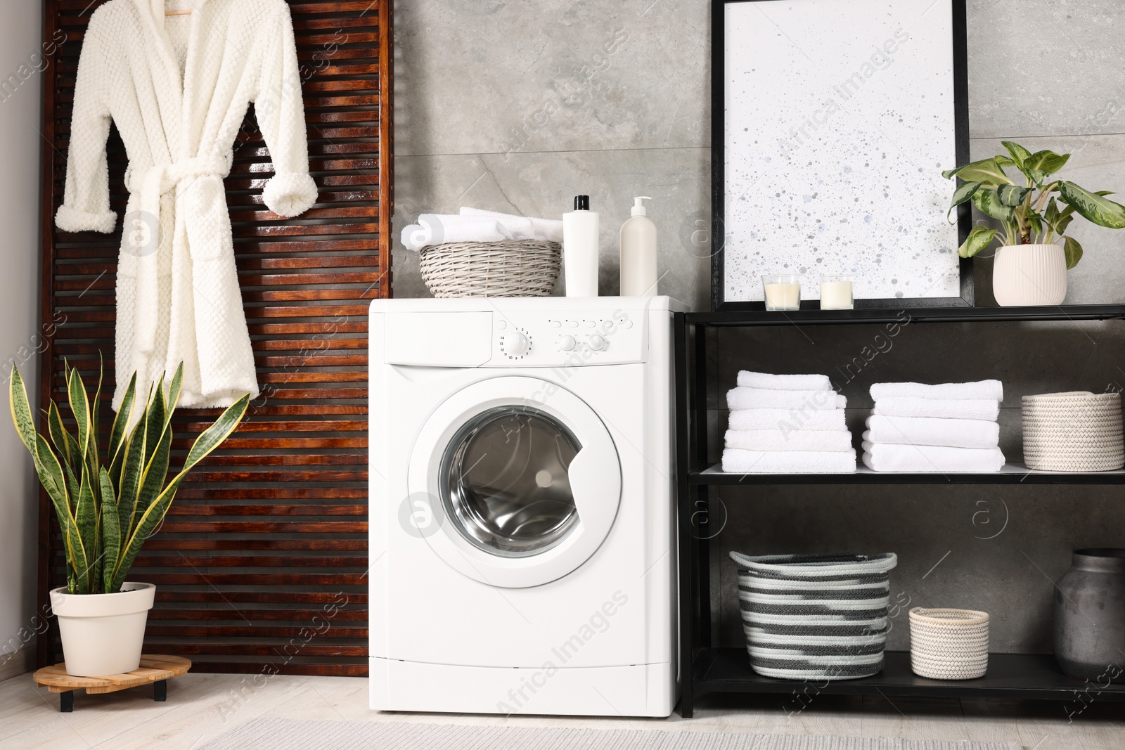 Photo of Stylish laundry room with modern washing machine. Interior design