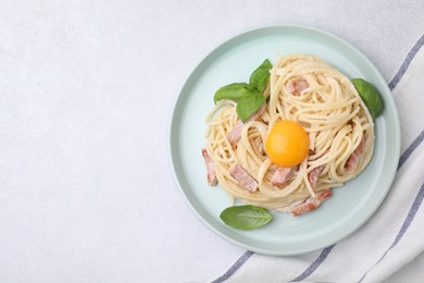 Delicious pasta Carbonara with egg yolk on white table, top view. Space for text