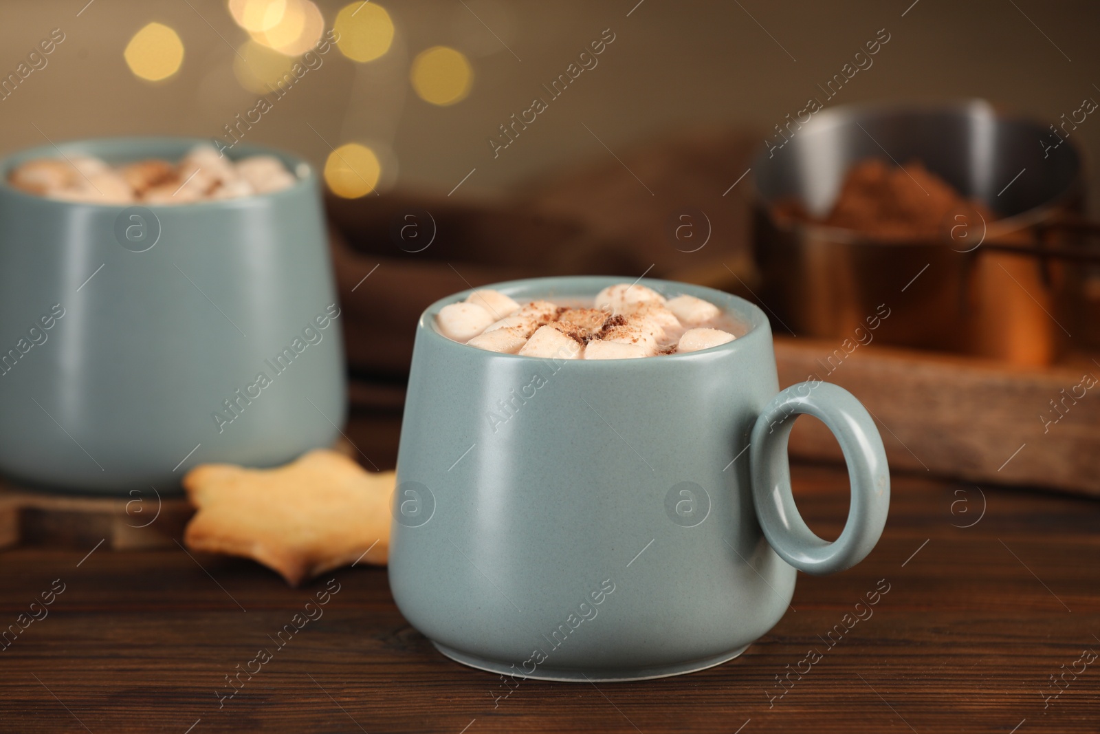 Photo of Cups of aromatic hot chocolate with marshmallows and cocoa powder on wooden table, closeup