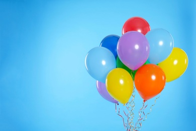 Photo of Bunch of bright balloons on color background. Space for text