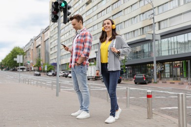 Photo of Young people near pedestrian crossing with traffic lights