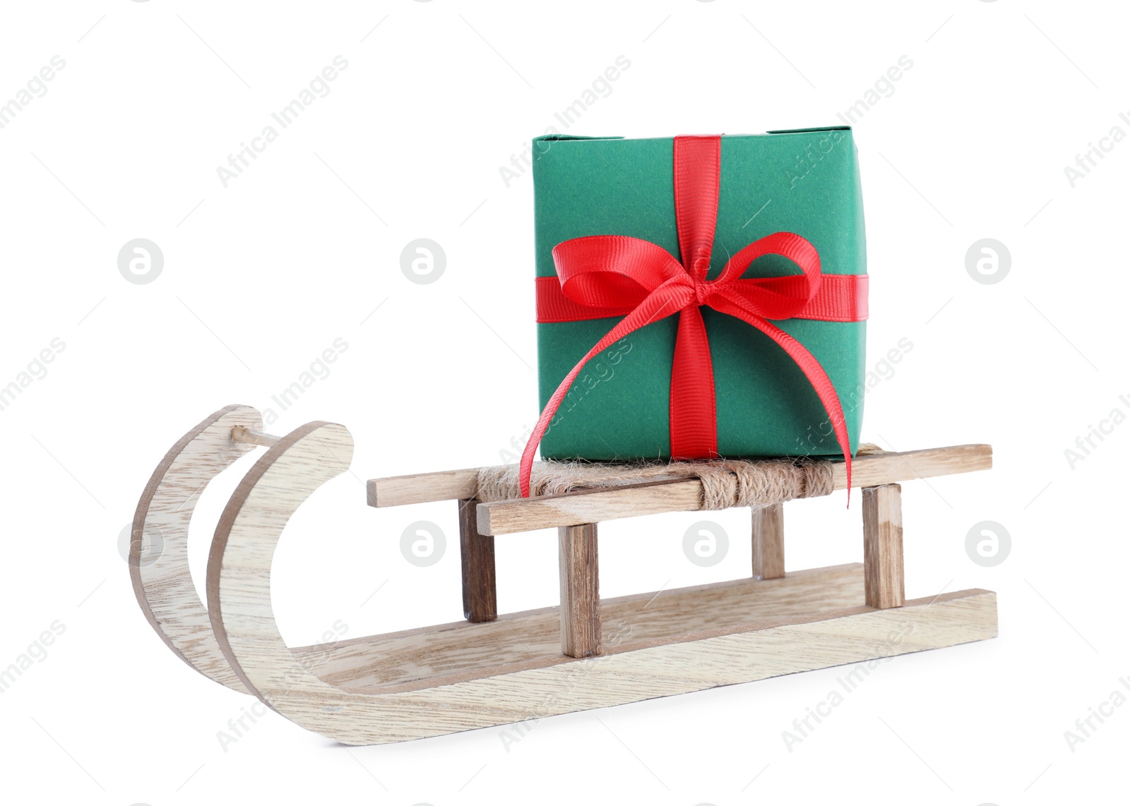 Photo of Wooden sleigh with gift box isolated on white. Christmas holiday decor