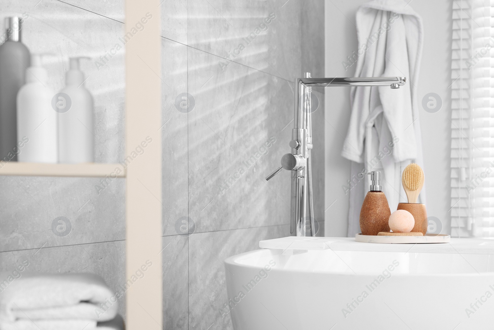 Photo of Different personal care products and accessories on bath tub in bathroom