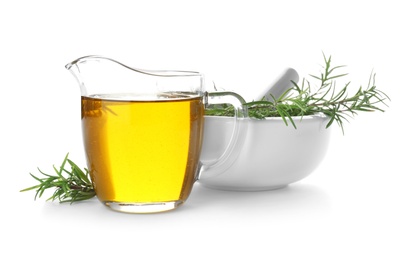 Photo of Jug of oil and fresh herb in mortar on white background