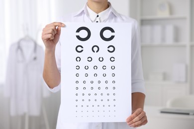 Photo of Ophthalmologist with vision test chart in clinic, closeup