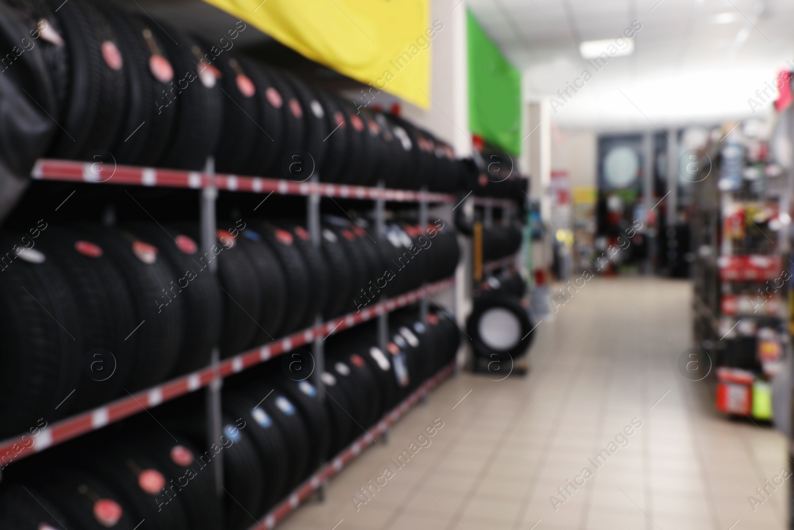 Photo of Blurred view of car tires on rack in auto store