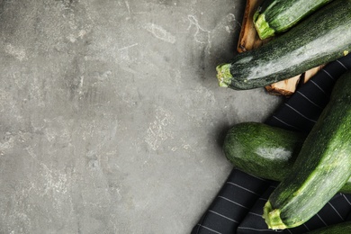 Photo of Flat lay composition with fresh ripe zucchinis on grey table, space for text
