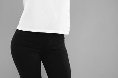 Photo of Woman wearing stylish black jeans on light gray background, closeup. Space for text