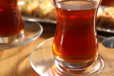 Traditional Turkish tea in glasses on wooden table, closeup