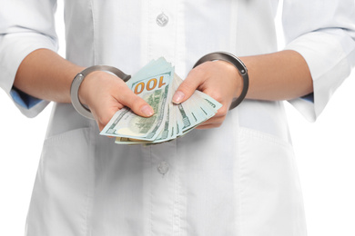 Photo of Doctor in handcuffs with bribe on white background, closeup. Corrupted medicine