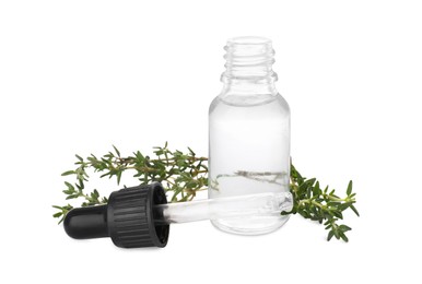 Photo of Bottle of thyme essential oil and fresh green sprigs on white background