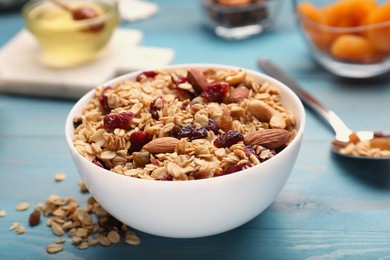 Photo of Tasty granola with nuts and dry fruits on light blue wooden table