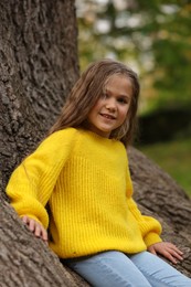 Photo of Portrait of cute girl near tree in autumn park