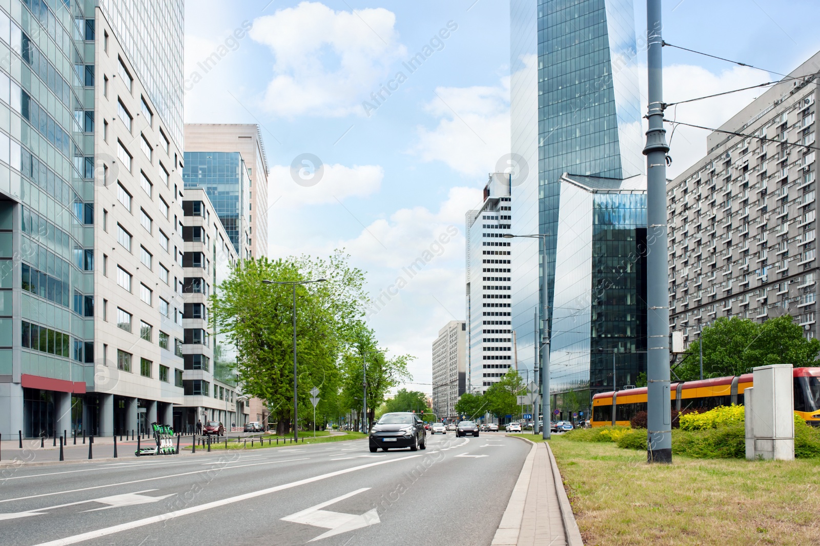 Photo of Road, cars and beautiful buildings on cloudy day in city