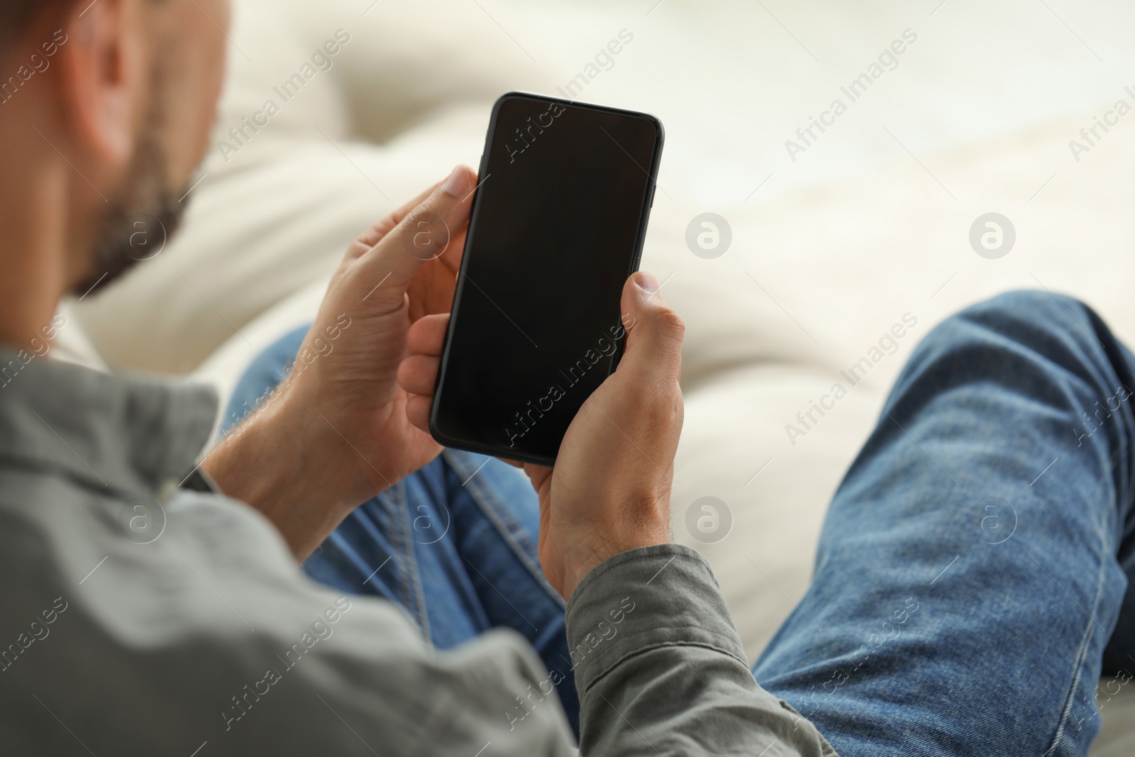 Photo of Man using smartphone indoors, closeup of hands