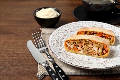 Pieces of delicious strudel with chicken and vegetables served on wooden table