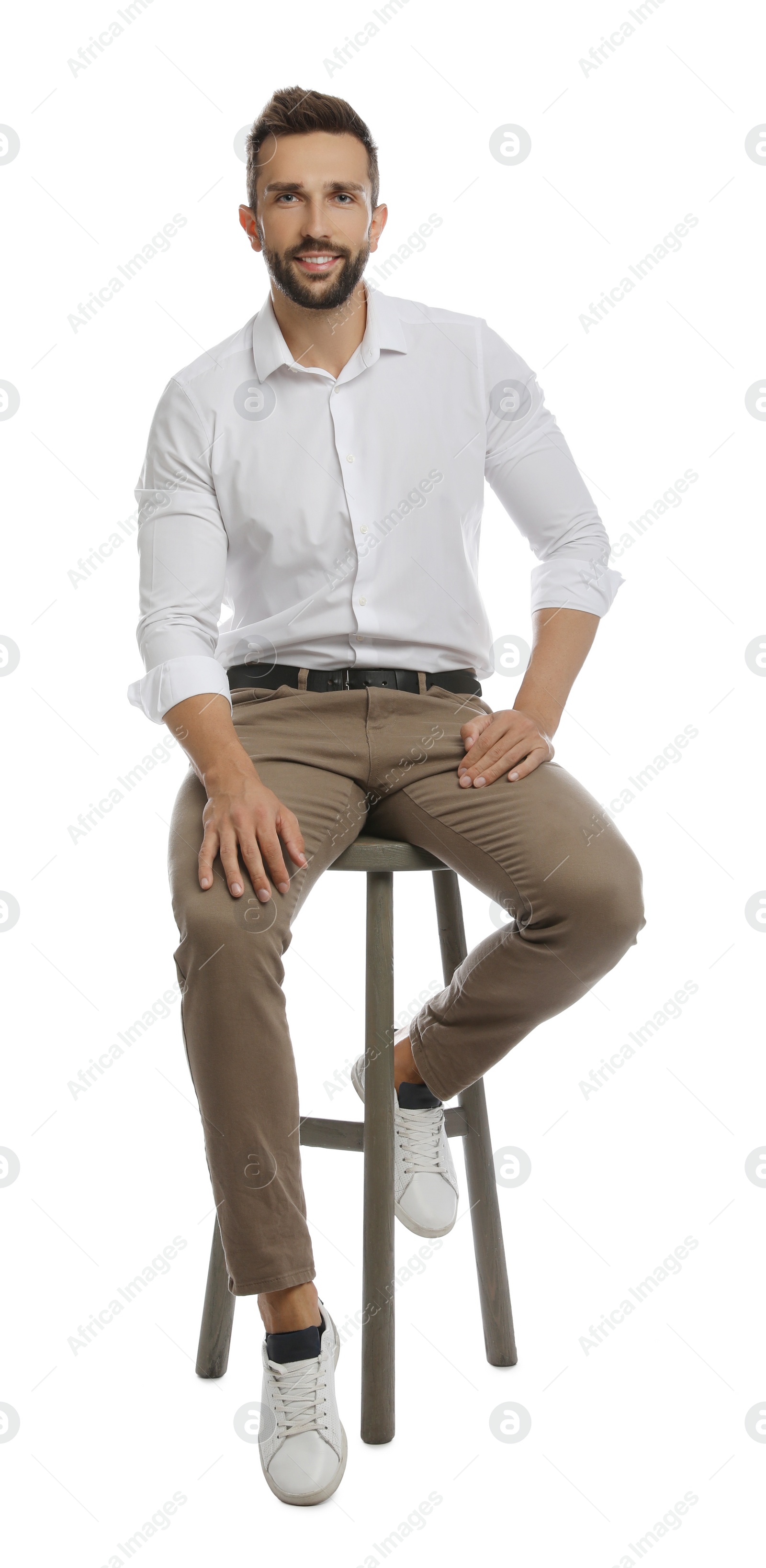 Photo of Handsome man sitting on stool against white background