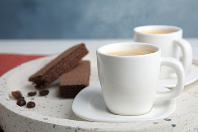 Photo of Delicious coffee and wafers for breakfast on tray, closeup. Space for text