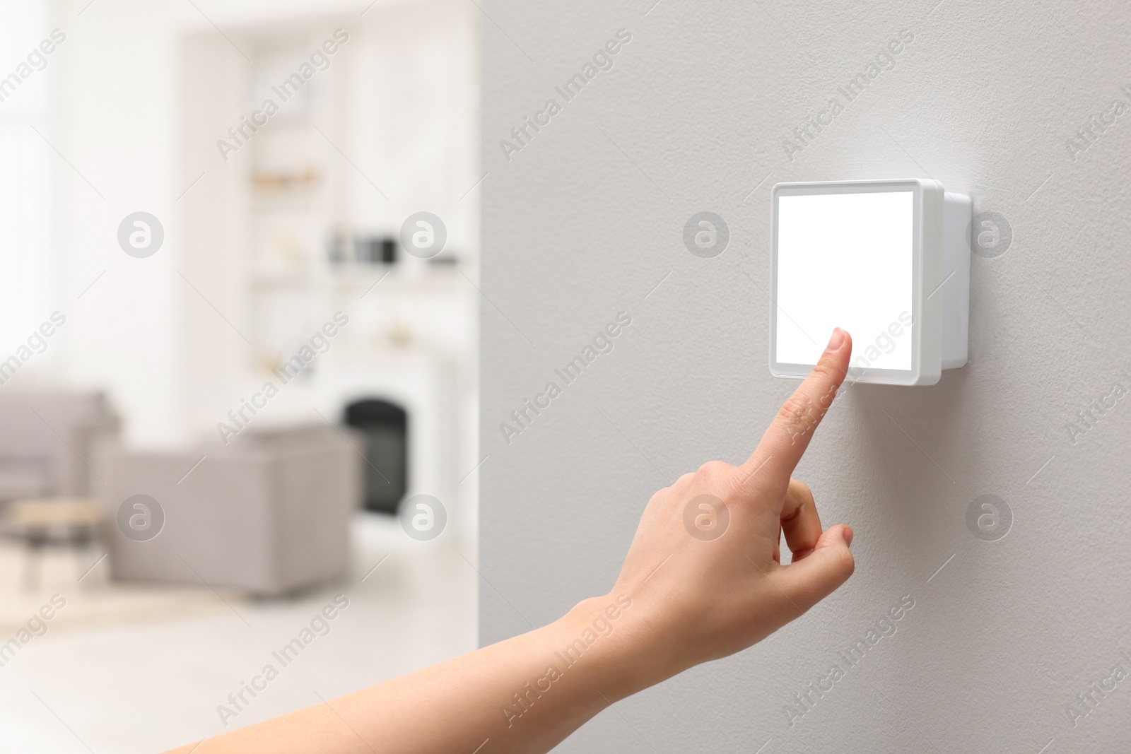 Photo of Woman adjusting thermostat on white wall indoors, closeup and space for text. Smart home system