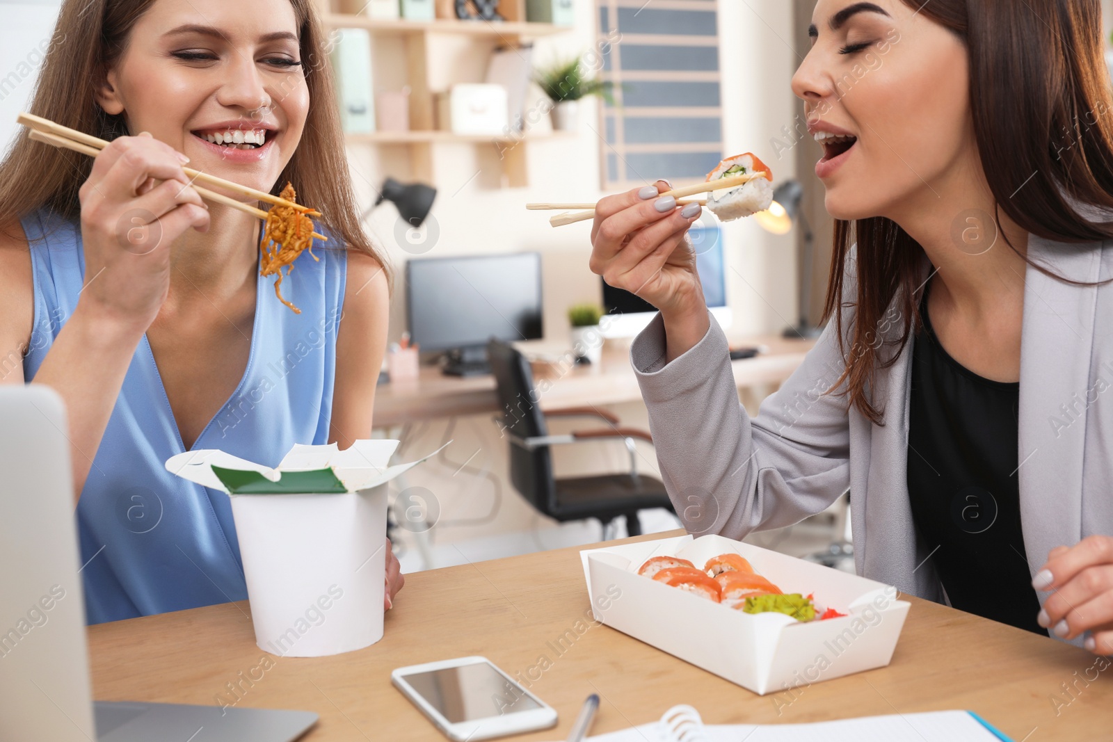 Photo of Office employees having lunch at workplace. Food delivery