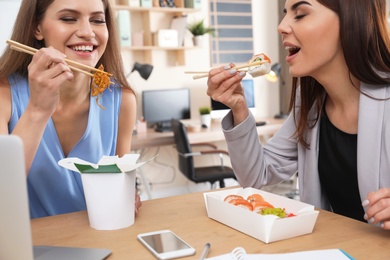 Office employees having lunch at workplace. Food delivery