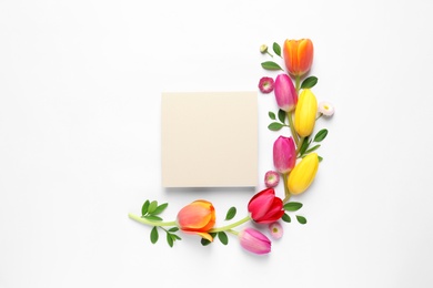 Photo of Beautiful composition with spring flowers and blank card on white background, top view. Space for text