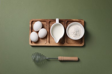 Photo of Metal whisk and dough ingredients on khaki background, flat lay