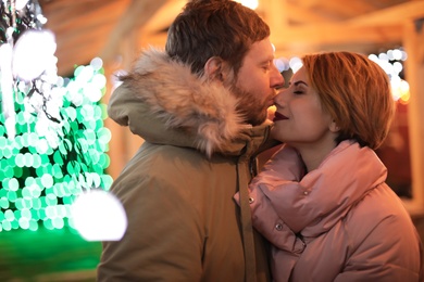 Cute couple in warm clothes at winter fair