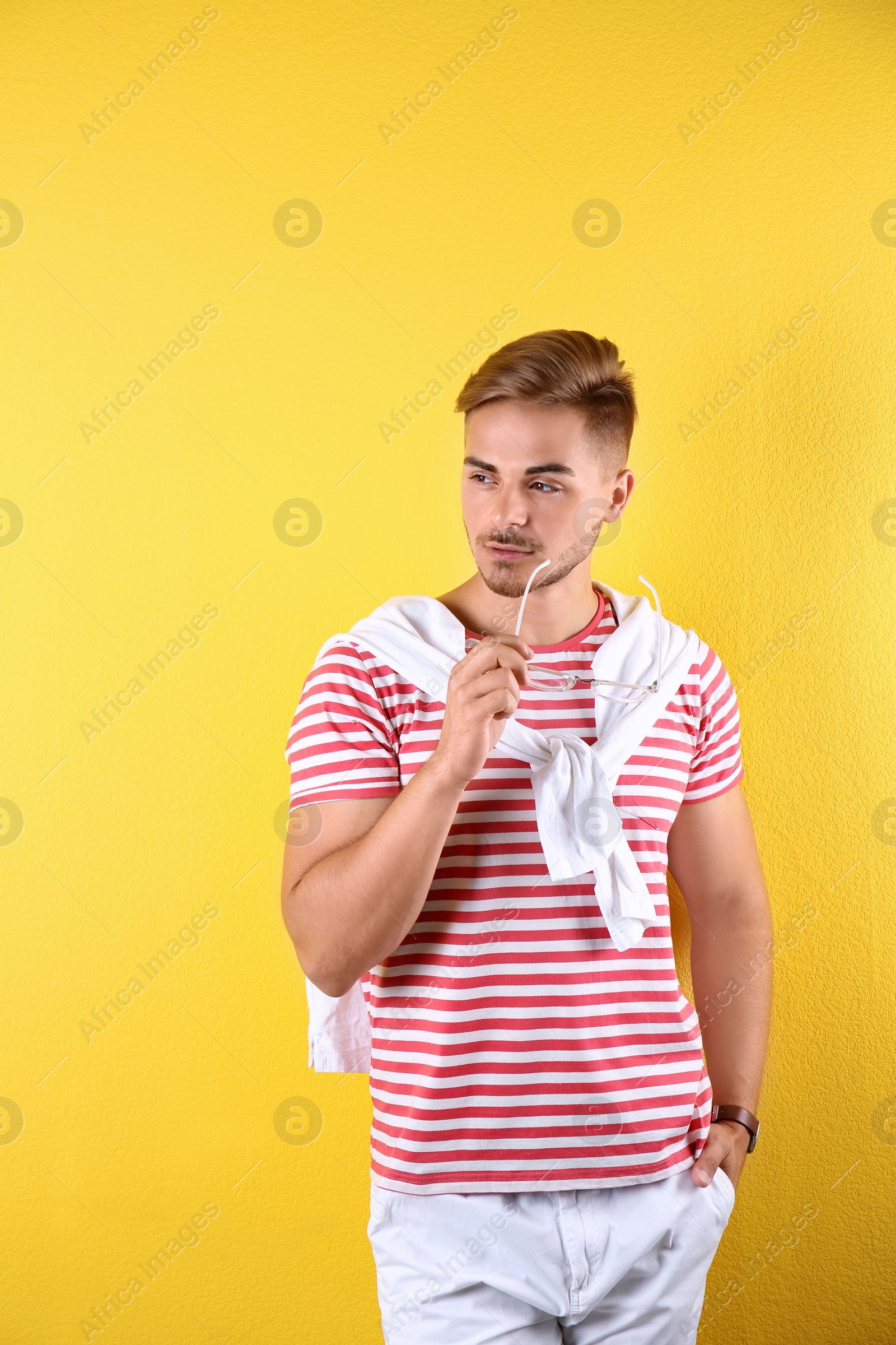 Photo of Young man with trendy hairstyle on color background